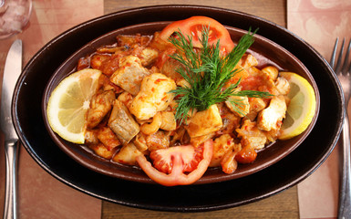 Chicken meal with vegetables in the guvec (Turkish cuisine) on the restaurant table