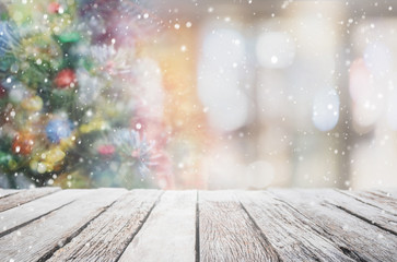 Empty wood table top on blur with bokeh Christmas tree and new's year decoration on window background with snowfall - can be used for display or montage your products. - 298765752