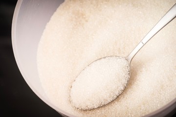 Closed up shot of Raw Sugar in a container. Unhealthy eating concept