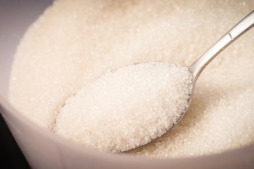 Closed up shot of Raw Sugar in a container. Unhealthy eating concept