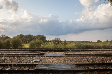 Railway tracks, rails and platforms in a rural train station in Uljma, Serbia, taken during a sunny sunset after a rain