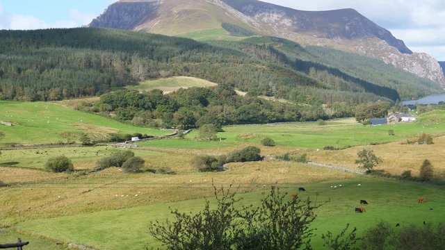 Mountain lake landscape of Snowdonia, North Wales from inside of moving train, handheld camera.