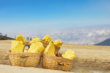 Heavy basket laden by pieces of natural sulfur to carry by miners from crater mine. Manual labour...