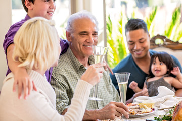 Obraz na płótnie Canvas Multi generation family smiling and enjoying a holiday meal