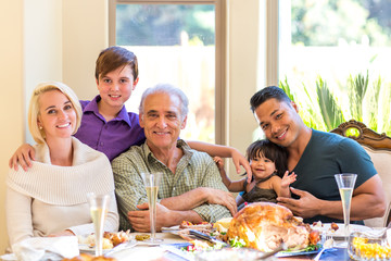 Multi generation family having a holiday dinner smiling at camera for a family photo