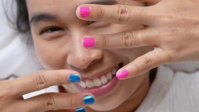 Close-up of female showing hands paint nail varnish, self made manicure at home.