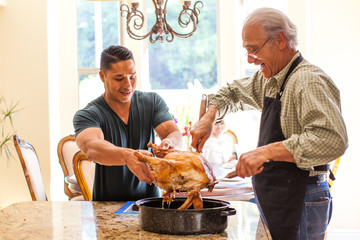 Father and his son in law preparing turkey holiday dinner
