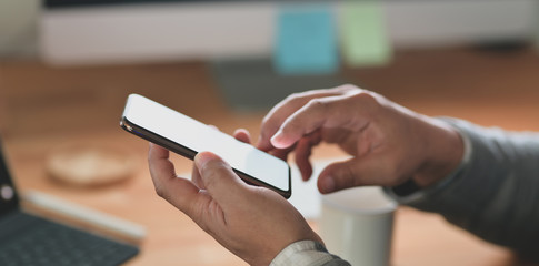 Close-up view of professional businessman looking at his blank screen smartphone
