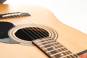 Modern acoustic guitar on white background, closeup view