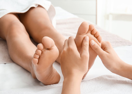 Young woman having feet massage in spa salon