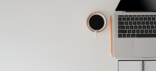 Top view of modern workspace with laptop computer, office supplies and coffee cup