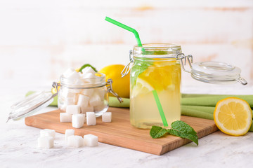 Jar of tasty lemonade with sugar on white table
