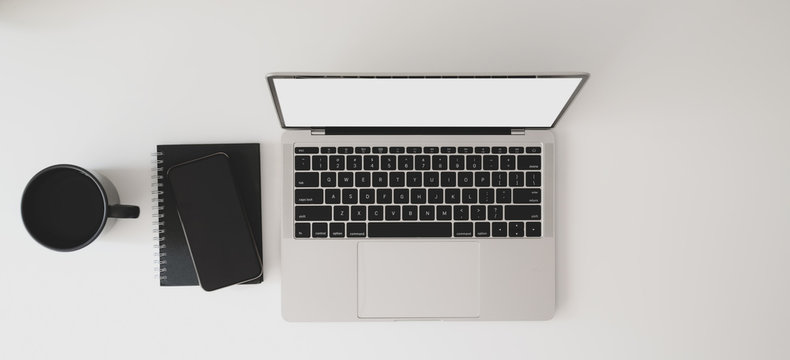 Top view of modern workspace with laptop computer, notebook and coffee cup