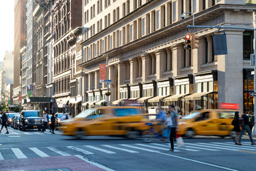The intersection of 23rd Street and 5th Avenue is busy with taxis and people during the rush hour commute in Midtown Manhattan New York City