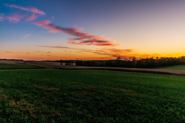 Obraz na płótnie Canvas sunset over green field