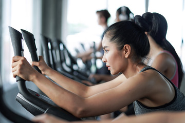 Young people running on a treadmill in gym.