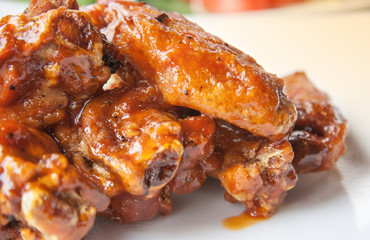 Close up barbecue chicken wings on white plate shot with selective focus