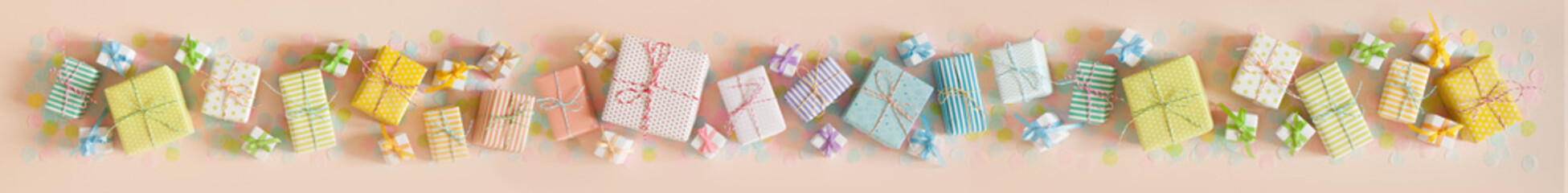 Gift boxes in pastel color. Pink long background.