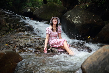 A woman playing in the Phlio waterfall, Chanthaburi, Thailand