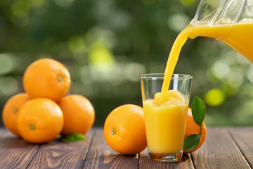 orange juice pouring in glass - obrazy, fototapety, plakaty