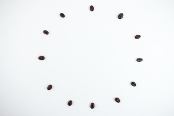 Coffee beans arranged in a circle on a white background.