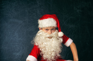 Portrait of a boy in the image of Santa Claus . Merry Christmas
