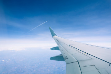 Wing of an airplane flying above the clouds