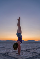 Fototapeta na wymiar Beautiful Woman Doing Handstands In The Bonneville Salt Flats