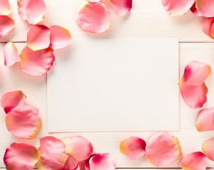 Pink fabric rose petals border over white wood table background top view from above - marriage, love, wedding or valentine's day background