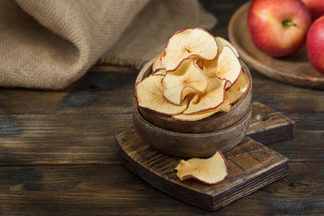 Fototapeta na wymiar Apple chips in a wooden bowl on a wooden table. Rustic style