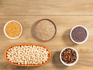 Mung bean, mustard seeds, fenugreek, cumin, cloves on brown wooden background. Indian cuisine,...