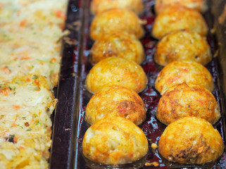 Takoyaki are cooked on the hot stove. Japanese appetizers.