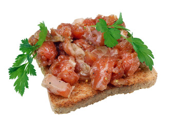 A sandwich for a tough guy. On bread a thick layer of salmon tartare and a small leaf of parsley  isolated macro