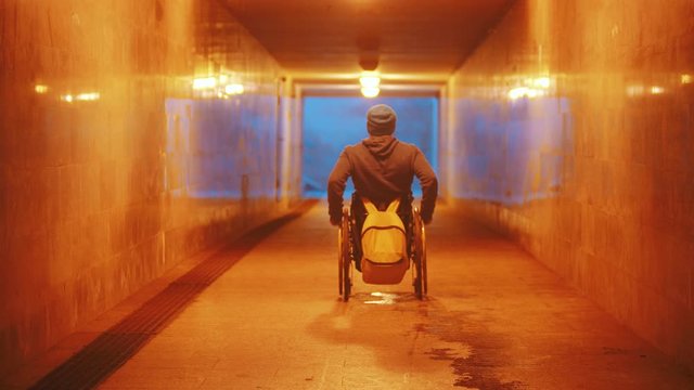 Disabled man in wheelchair riding in the empty underpass