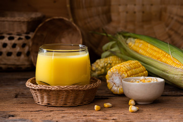 Fresh sweet corn juice (corn milk) and corn on wood background