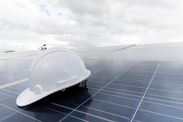 Engineering cap on solar panel with white clouds background,