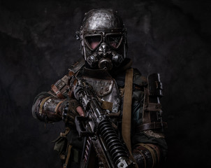 Cool cosplay costume of post - apocalypse knight, man is posing at dark photo studio.