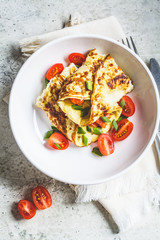Omelet with salmon, cheese and green onions on white plate. Keto diet menu concept.