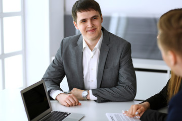 Businessman headshot at meeting or negotiation in modern office. Unknown entrepreneur sitting with diverse colleagues at the background. Teamwork, partnership and multi ethnic group concept