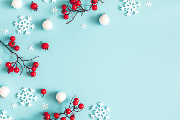 Christmas or winter composition. Snowflakes and red berries on blue background. Christmas, winter,...