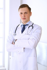 Doctor man standing straight in medical office or clinic. Medicine and healthcare concept