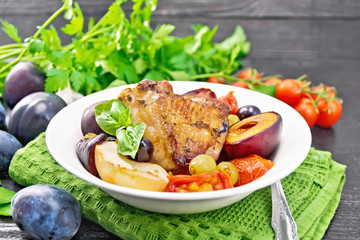 Chicken with fruits and tomatoes in plate on board