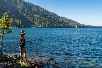 Fototapeta na wymiar Woman Fishing in Lake Tahoe During Sunset