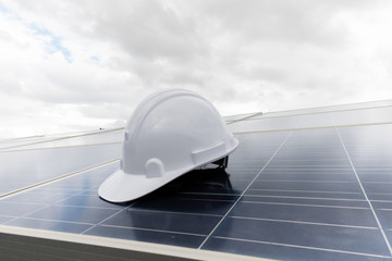 Engineering cap on solar panel with white clouds background,