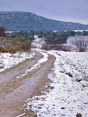 Dirt road with mud on snow covered landscape, Pieria, Greece.