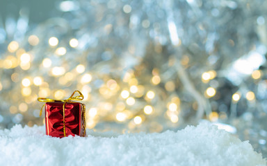 Gifts box in the snow on white bokeh background,