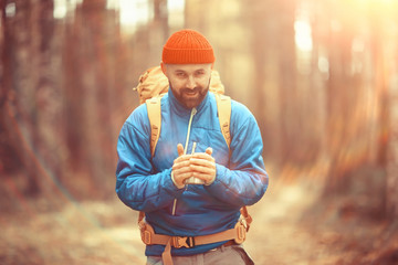 Obraz premium hot drink on the hike, a man drinks hot on the hike, adventure forest October
