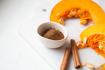 pumpkins with cinnamon sticks on marble backgrund
