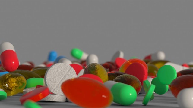 Medicine pills and capsules are falling on a surface