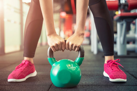 Closeup of people exercise with kettlebell at gym. Sport workout and fitness.
